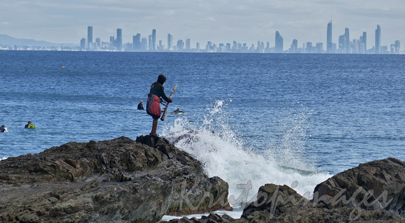 Aboriginal indigenous man with didgeridoo stands on Snappers rocks and repeats a daily ritua-1l