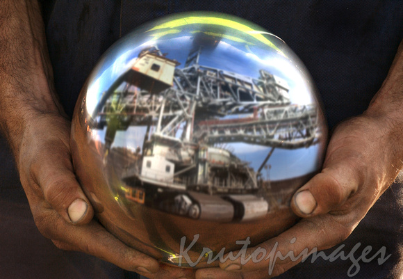 maintenance, mans hands with large ball bearing from mine dredge.