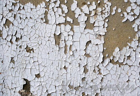 detail of old lead paint on concrete breaking down and flaking off.