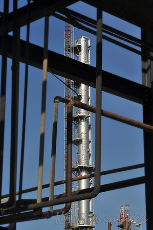 Large tower for processing at a petro-chemical plant in Victoria seen through a gantry framework