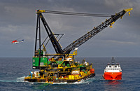 DB30 derrick barge laing pipe in Bass Strait with workboat and helicopter leaving vessel