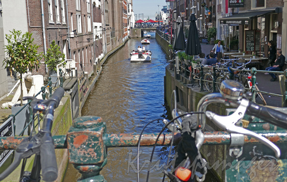 Amsterdam one of the many canals and  a couple of the many many bicycles