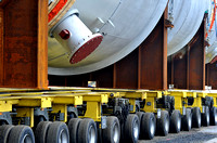 detail of a multi wheeled heavy haulage vehicle transporting huge vessels to a refinery