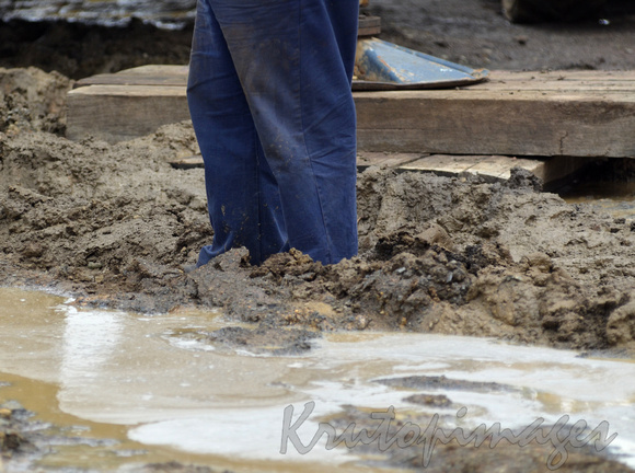 worker in a muddy site during maintenance
