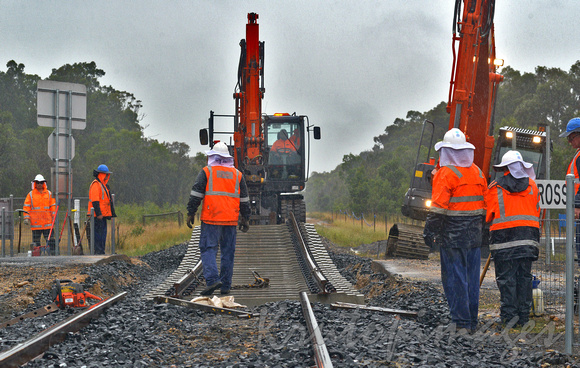 railway workers constructing a new crossing on a wet remote Victorian rail line