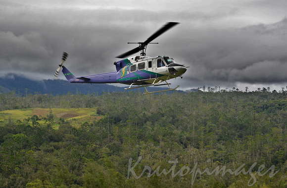 helicopter rises through the humidity and pending storms in Papua New Guinea highlands district