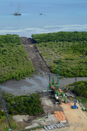 PNG- machinery claiming swampland and constructing a road to lay pipeline across to vessel , in Papua New Guinea re LNG gas