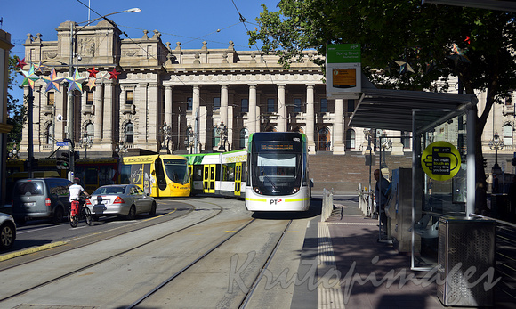 Trams pass Parliament House on Spring Street Melbourne CBD