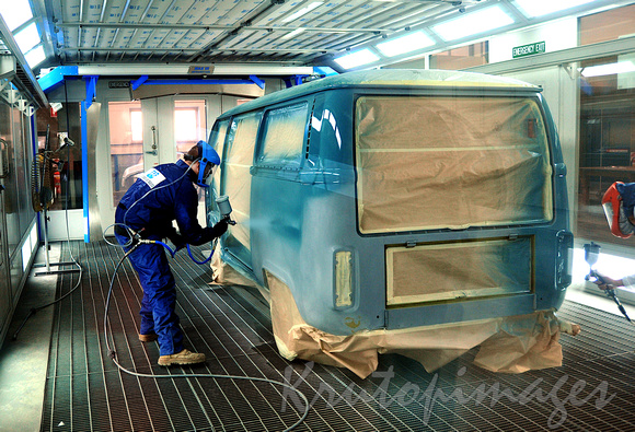 Trainees at work as vehicle spray painters in a training module at school for apprentices