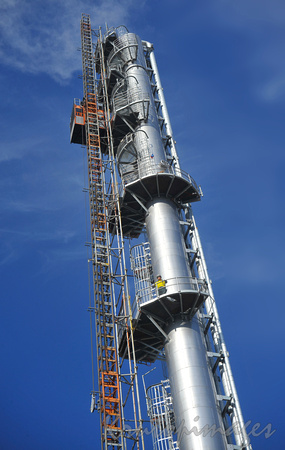 Petrochemicals and plastics refinery worker on high production tower