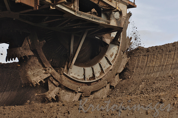 brown coal opencut mine with dredge bucket cutting into a layer wall