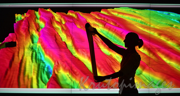 Geologist studies seismic mapping in front of exploration map on screen