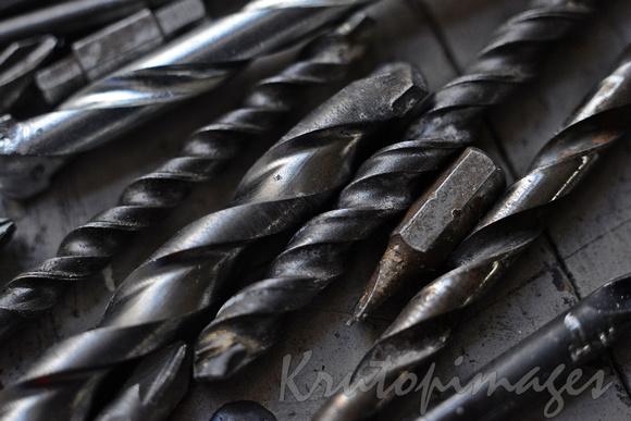 steel drill bits resting on a work bench