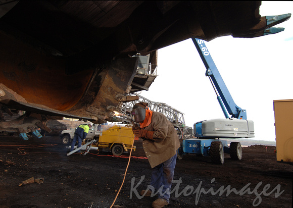 Welder at work on a dredge bucket in theopencut mine Gippsland Victoria