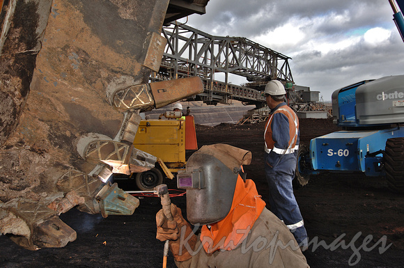 Welder at work on a dredge bucket in theopencut mine Gippsland Victoria-2