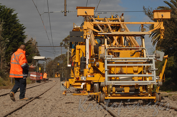 rail worker sets the levelling blades on a trck stomper after new track upgrades-Melbourne-2