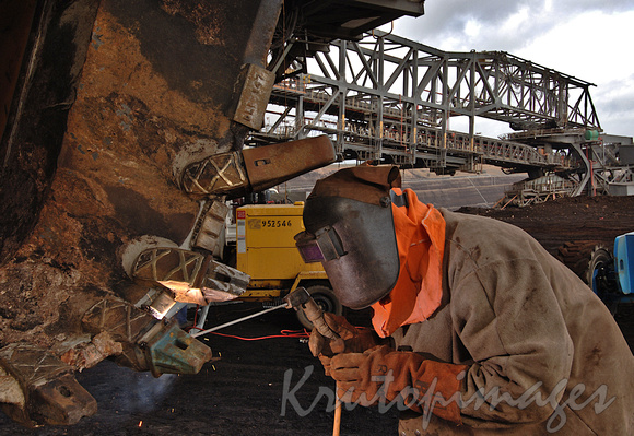 Welder at work on a dredge bucket in theopencut mine Gippsland Victoria-4