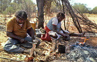 Aborigines at work in their desert environment and campfire Arnem Land NT