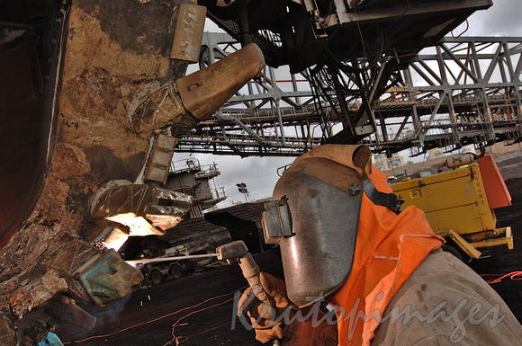 Welder at work on a dredge bucket in theopencut mine Gippsland Victoria-3