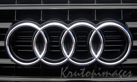 The familiar Audi logo on the front of a vehicle.