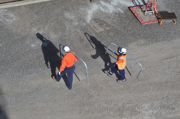 overhead view of a workers on site in ppe casting a long shadow