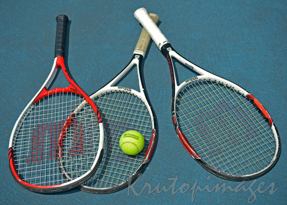 three tennis rackets and a ball