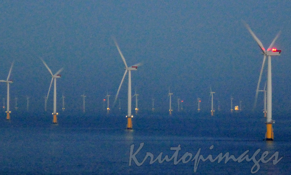 wind turbines supplying energy England at night.
