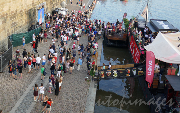 Prague, people queue to get onto the moored party boats.