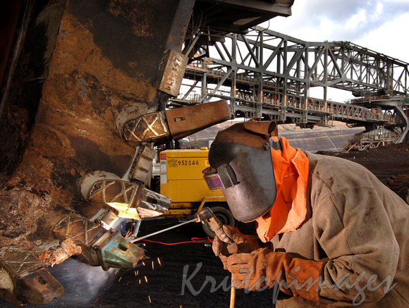 WElder at work on dredger wheel in the opencut mine