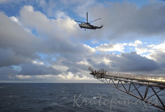 Helicopter lifts a flare onto offshore boom