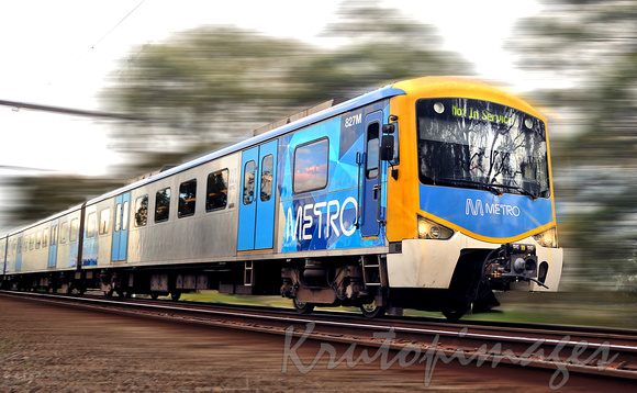 Metro train speeding past in outer suburbia Melbourne