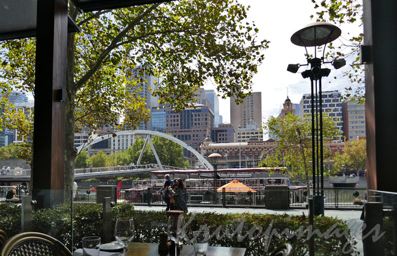 Melbourne Southbank generic streetscape and pedestrian crossover bridge  from inside a Yarra River restaurant