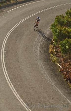 Cyclist on road bend -above
