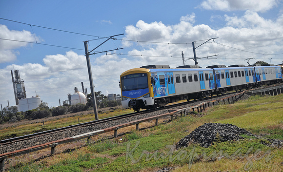 Train -passenger train passes Altona refinery
