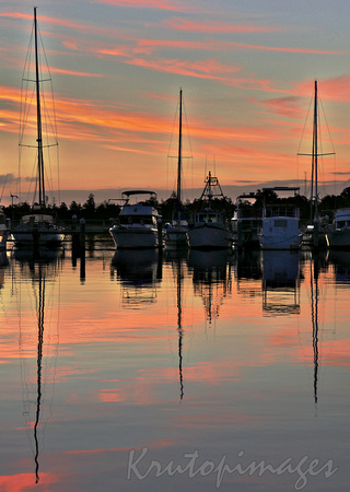 Boatsmoored at Lakes Entrance harbour during a brilliant pink sunset