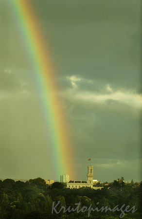 Government house during showers and under a rainboq