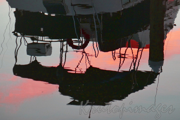 Moored boat reflection in water