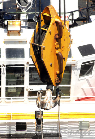 Heavy load is lowered onto ships main deck-detail of connected hook