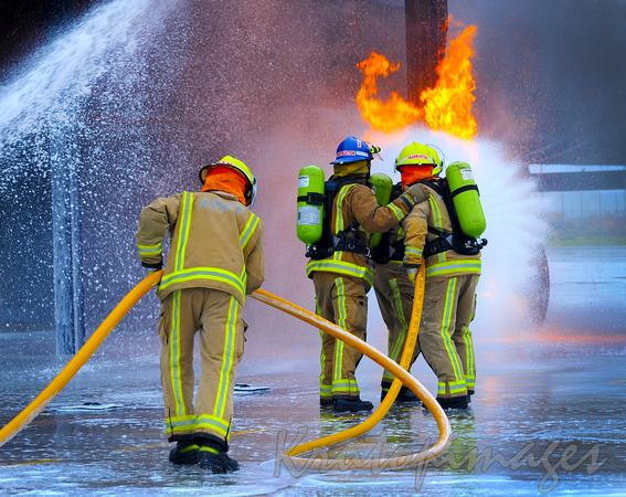Fire fighting training grounds men at work with full PPE and simulated gas leak fire