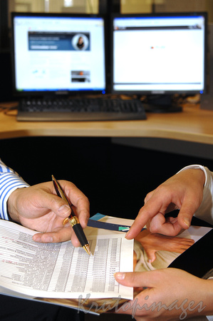 Business image-males hands working on a spread sheet hardcopy