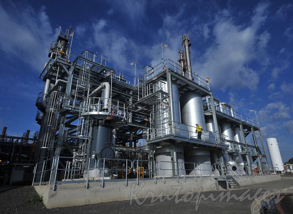 Petrochemicals and plastics refinery showing a worker on a production gantry